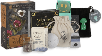 
  A collection of spiritual and wellness items including oracle cards, crystal bottles, a moon-themed pouch, 
  a book titled “The Witches’ Guide to Rituals,” and various small mystical tools and accessories.
