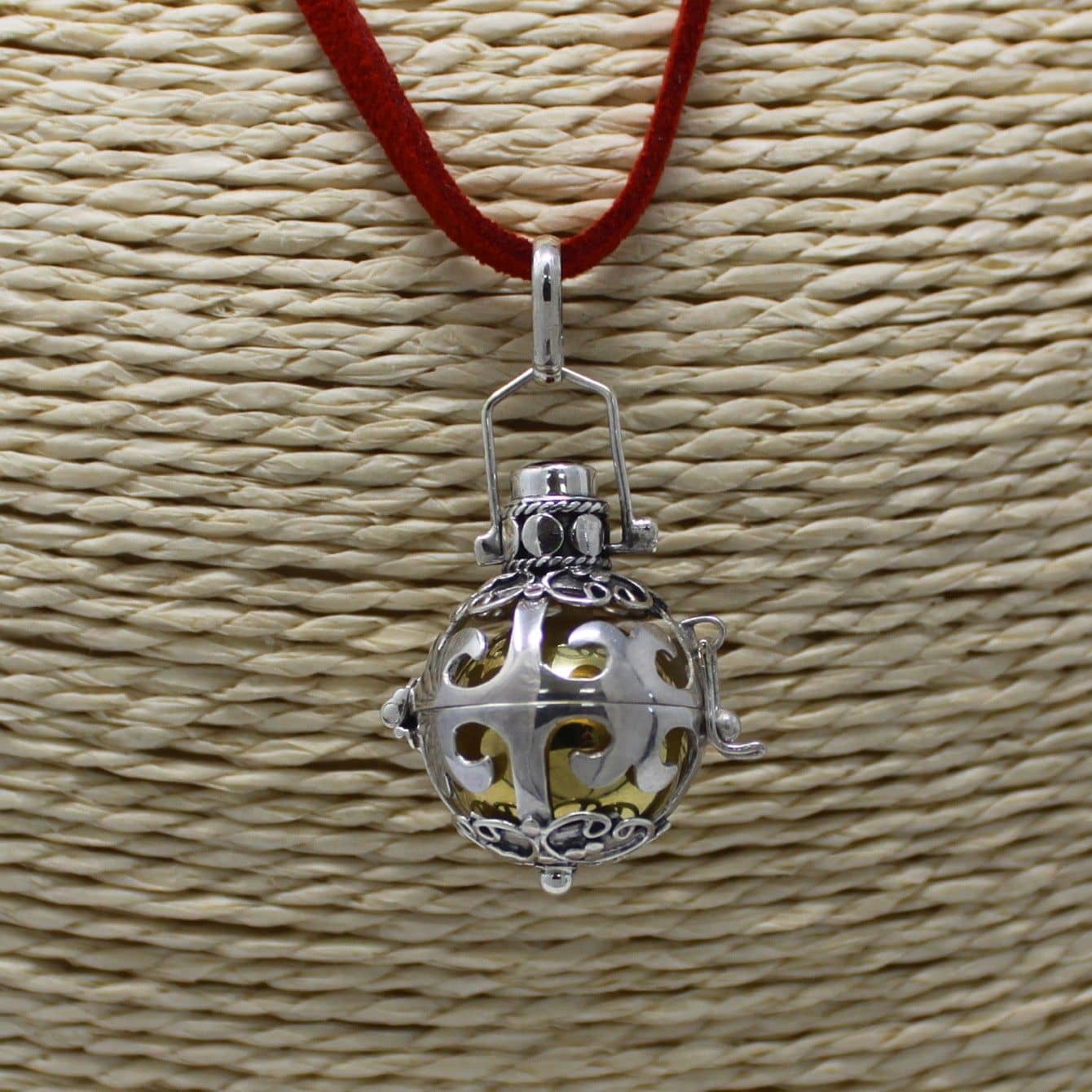 Silver angel bell necklace worn around the neck