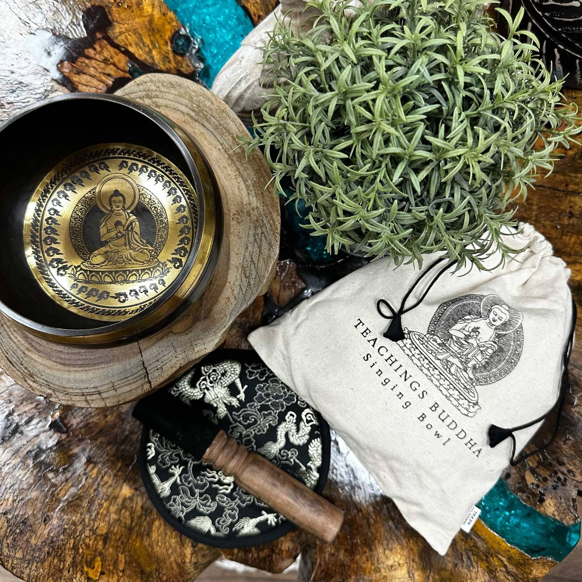 Brass singing bowl resting on its cushion with the mallet beside it