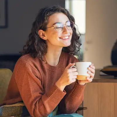Happy woman holding a cup of cofffee