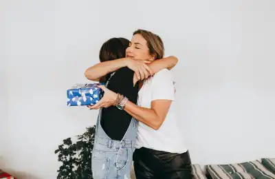 Image of a couple exchanging gifts and hugging.
