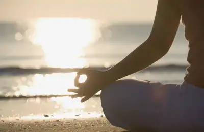 woman meditating on the beach