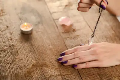 Someone holding a crystal pendulum