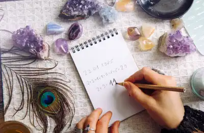 Someone writing in numbers surrounded by crystals.