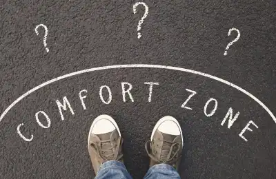 Image of 'comfort zone' written around someone's feet.