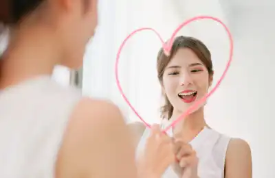 smiling woman drawing a love heart on the mirror