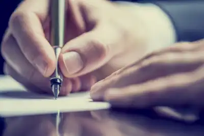 close up of person writing with pen on paper