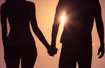 Couple holding hands at sunset