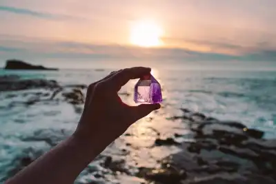 Someone holding a piece of Amethyst next to the sea
