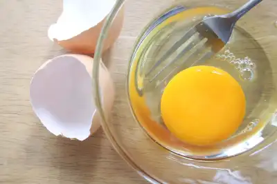 Raw egg in a bowl with egg shell