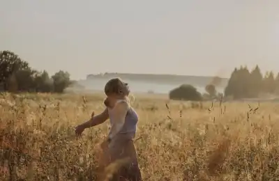 woman in wheat fiels with arms out