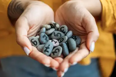 Hands holding lots of pebbles with different numbers on