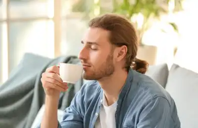 An image of a man smelling his morning coffee.