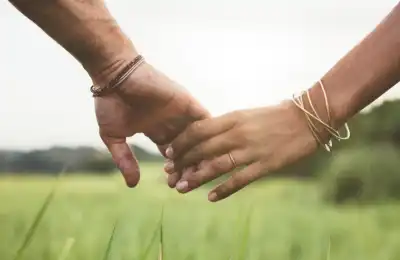 couple holding hands in field