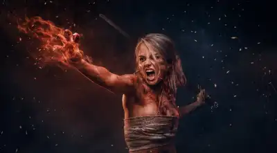 Woman warrior wearing rag cloth stained with blood and mud in the heat of battle, with fire coming from her hand