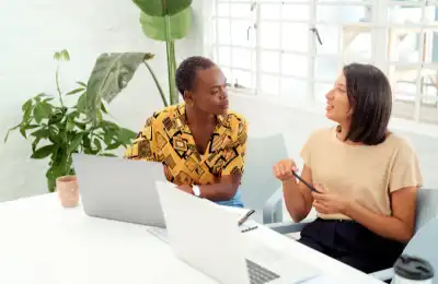 Two people talking to eachother in a meeting.