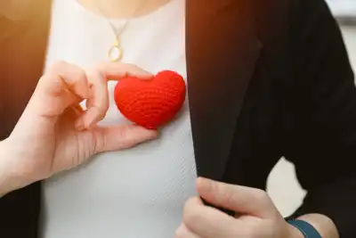Someone holding a crochet heart over her chest