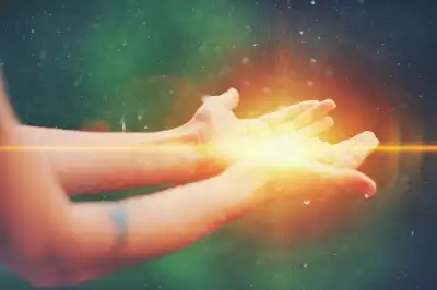 Two hands together, palms up with light radiating from the palms