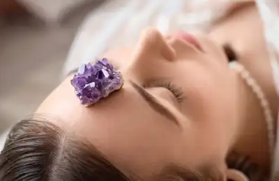 Image of an amethyst crystal on someones head.