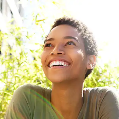 Close up portrait of a young woman smiling outdoors