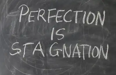 Image of a sign that says 'perfection is stagnation.'