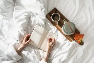 Relaxing journaling flatlay with notebook, pen and pot of tea