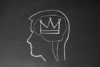 The outline of a head on a chalkboard with a crown drawn inside the brain
