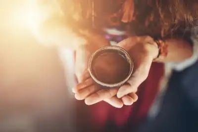 Someone holding a cup of Cacao in the palm of their hands