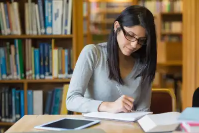 woman writing a novel plan in a notebook