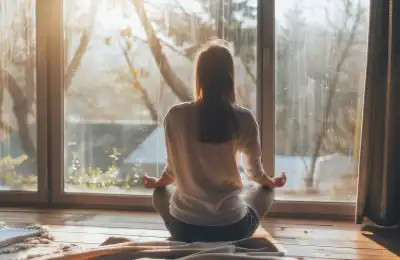 Someone meditating in front of a window.