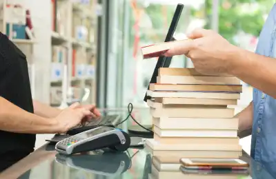 Image of someone buying a stack of books.