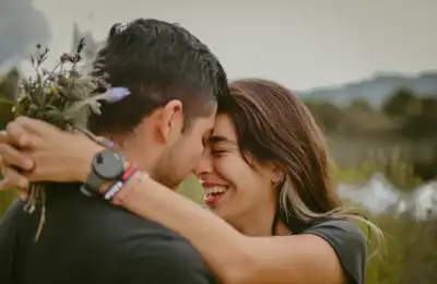 woman hugging man holding flowers