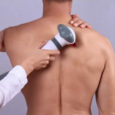 Therapist applying an infrared treatment on a man's back.