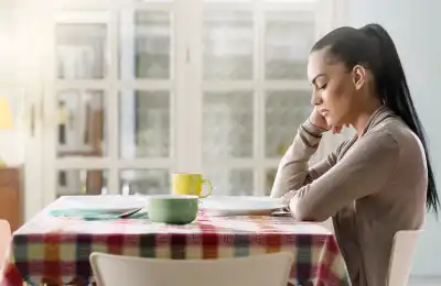 Image of someone sitting at the dining table by themself.