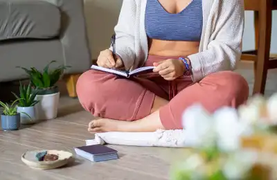 woman manifesting in journal sitting on floor