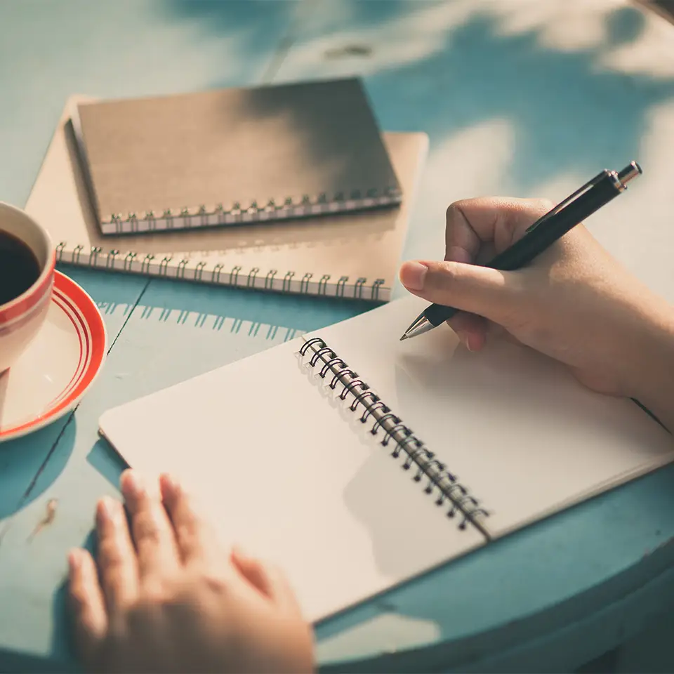 Hand posed, ready to write in a notebook