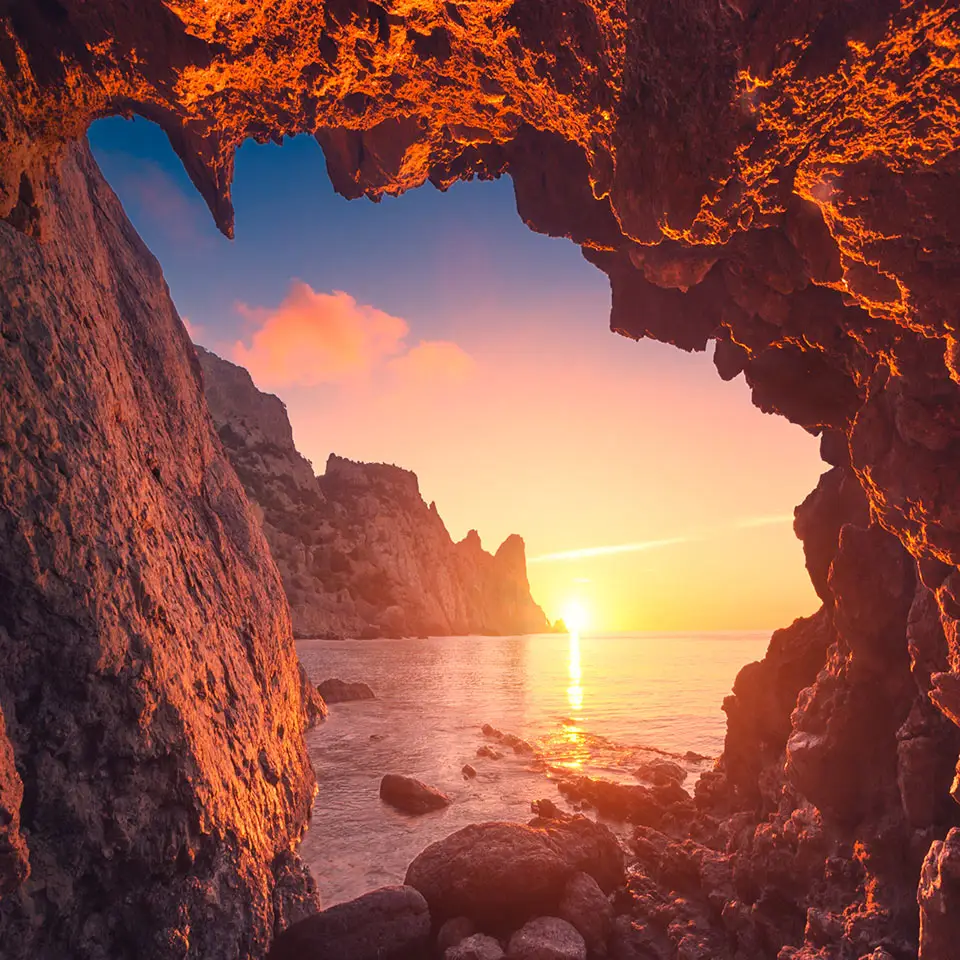 Beautiful sunrise from the mountain cave in a Crimea sea bay