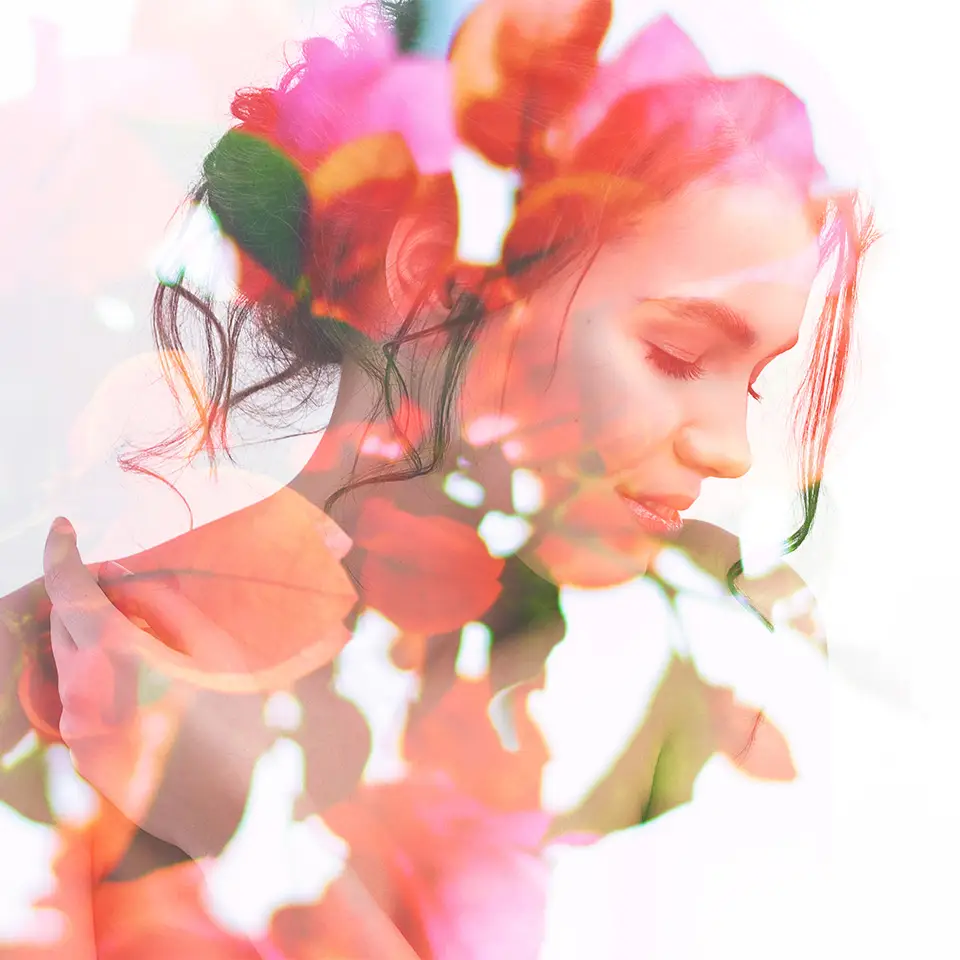 Double exposure portrait of young woman combined with photograph of bright spring garden flowers and leaves
