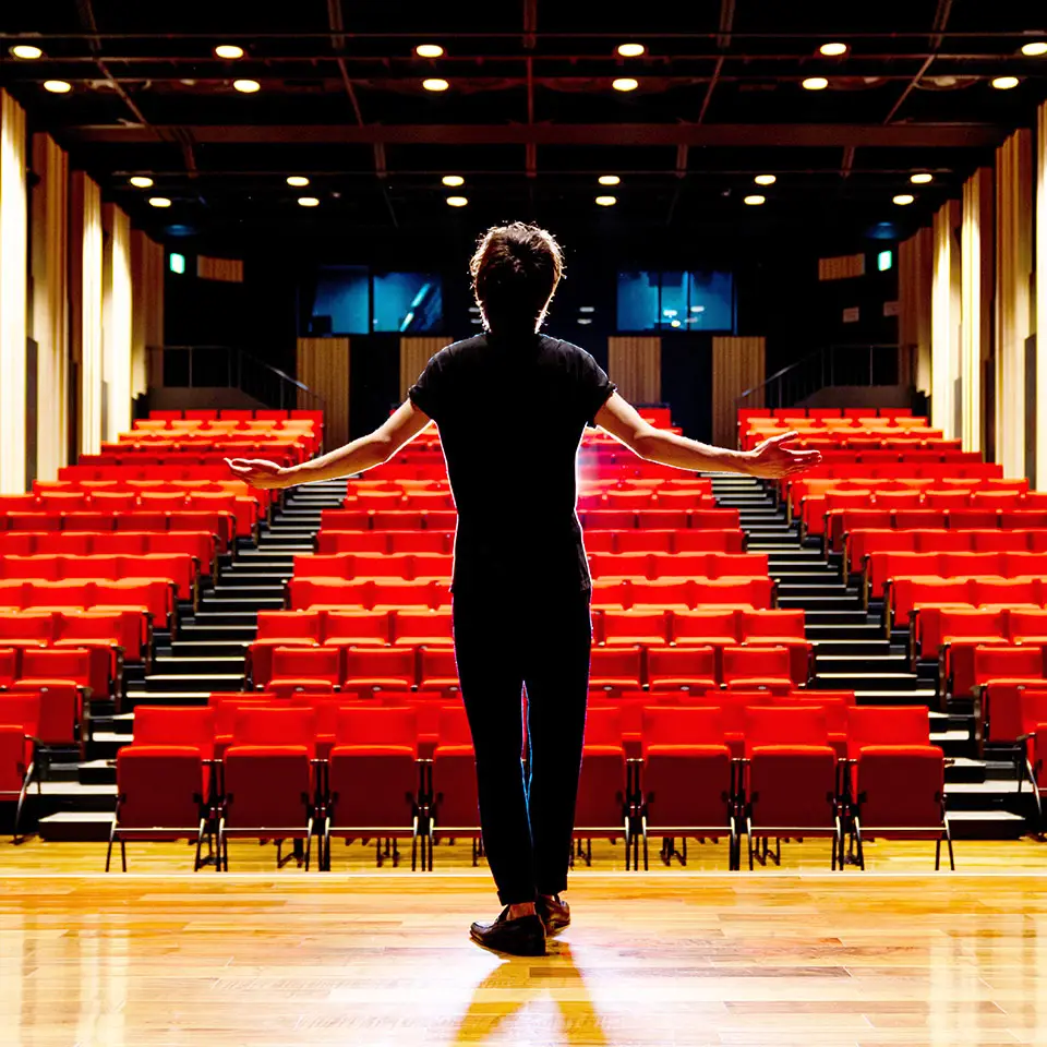 Young actor standing on the stage of a theatre