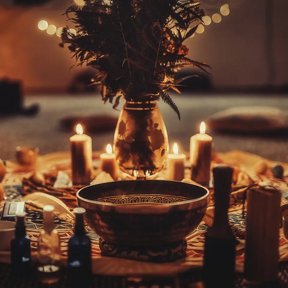 A bowl and candles laid out on the floor as part of a ceremony