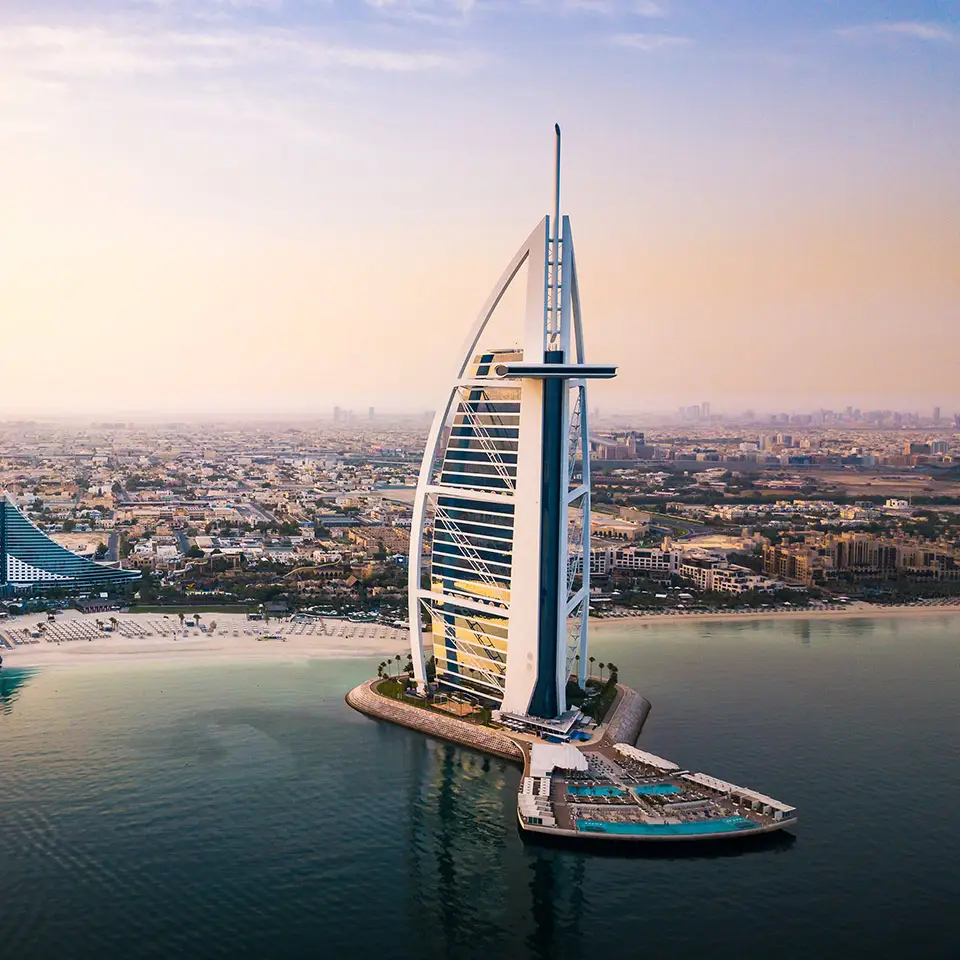 Dubai seaside skyline and Burj Al Arab luxury hotel aerial view at sunrise