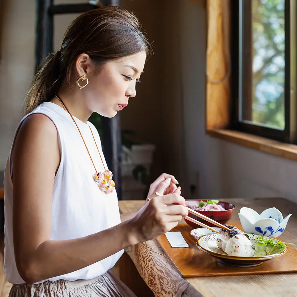 Japanese woman sitting at a table in a Japanese restaurant, eating
