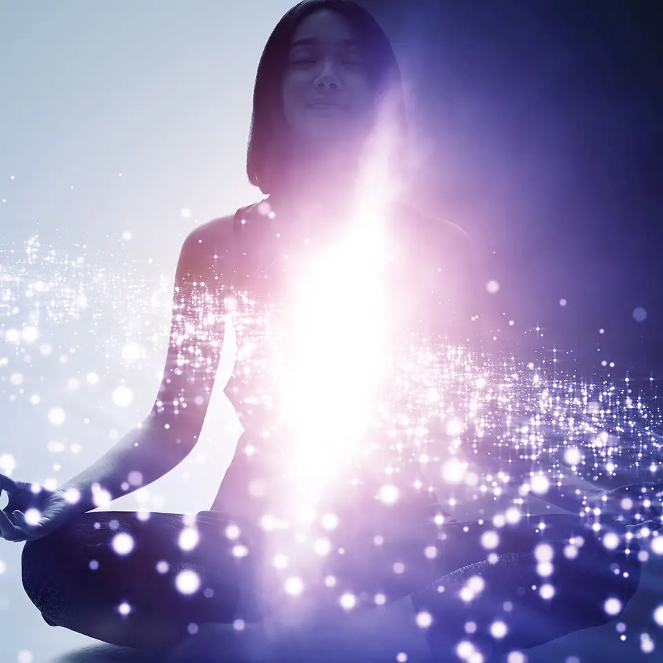 Woman in a meditating pose overlaid with a space scene