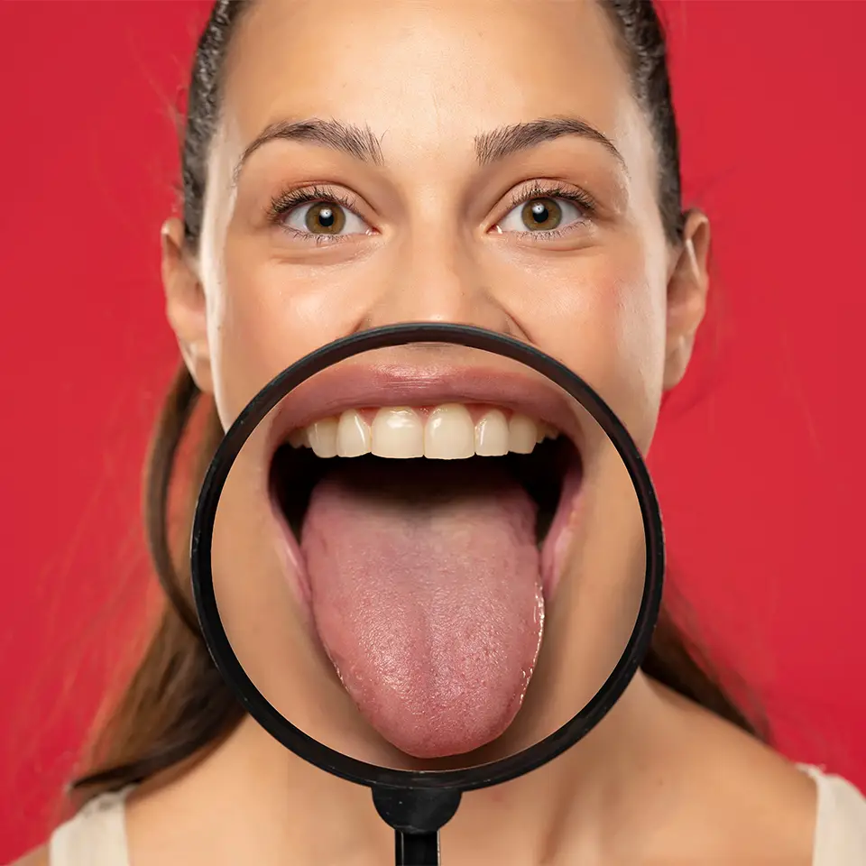 Person showing their tongue through a magnifying glass