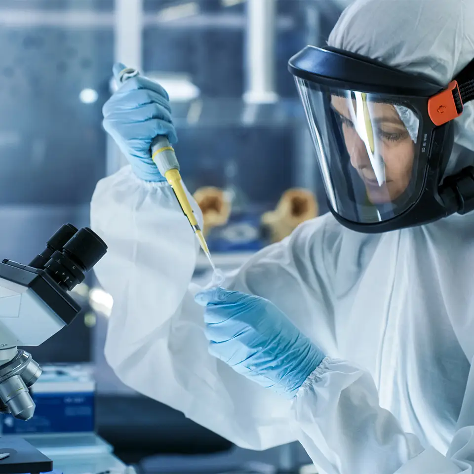 Medical virology research scientist working in a hazmat suit with a mask