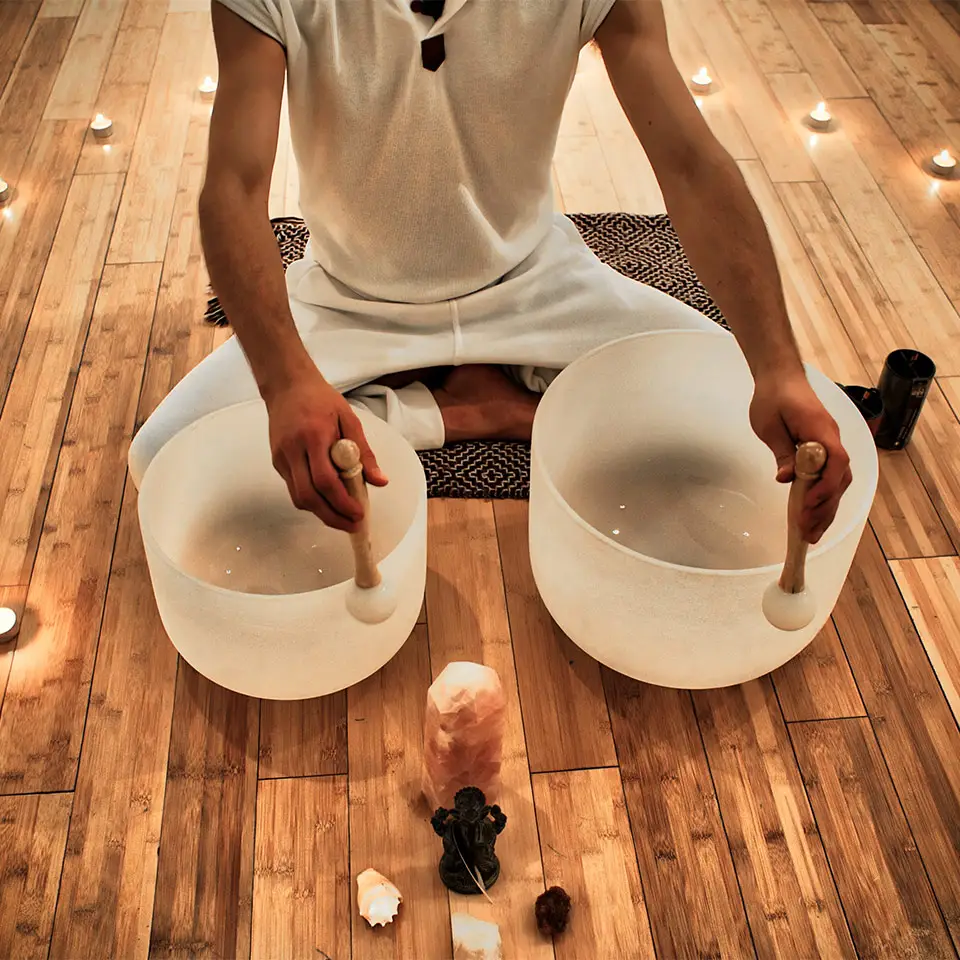 A man playing crystal bowls for sound healing