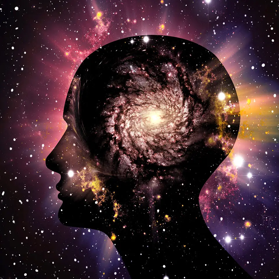 A silhouette of a human head in front of an image of space