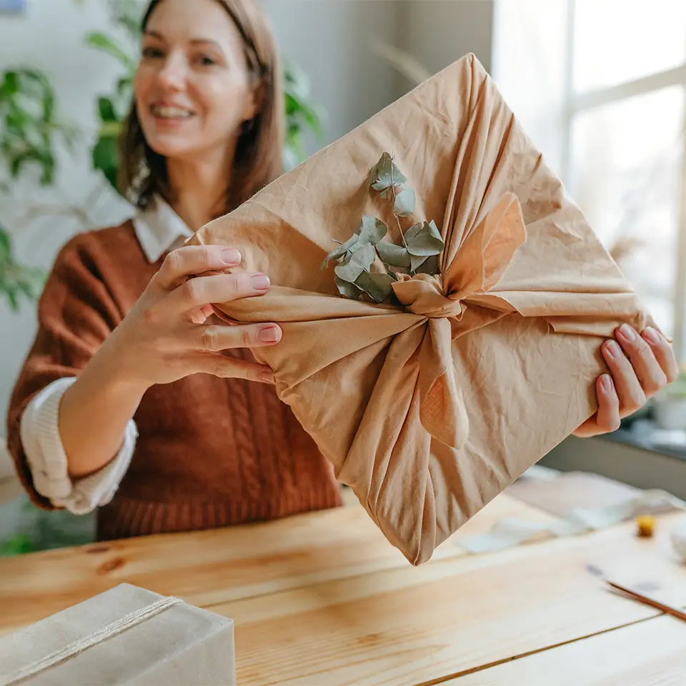 Etsy seller holding a gift-wrapped product from their store