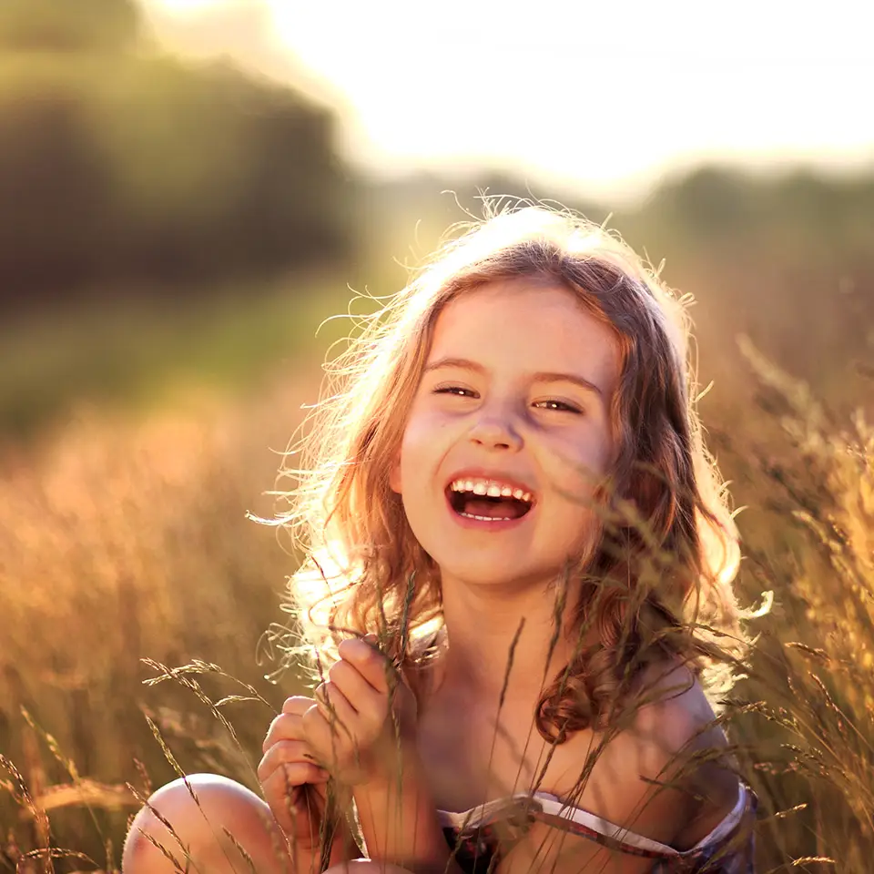 Young girl laughing in a meadow
