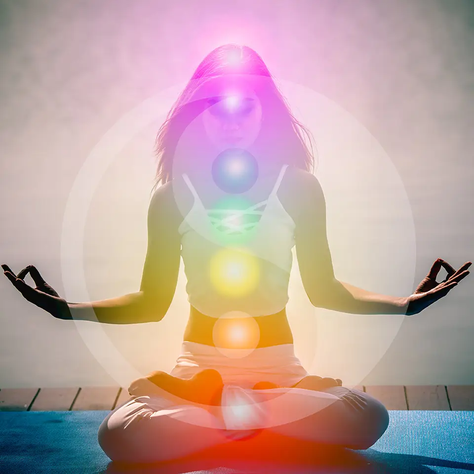 Woman in a yoga lotus pose with seven chakras, aura, spiritual and Yin Yang symbols